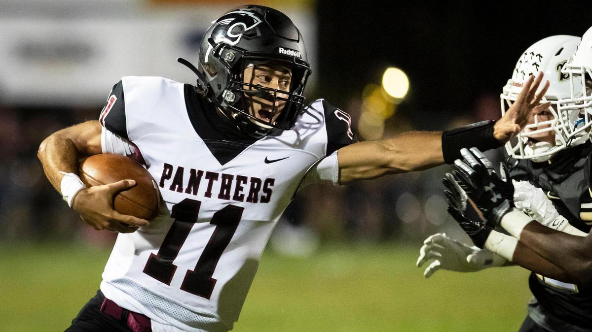 Carolina Forest quarterback Kyle Watkins (11) lays a stiff arm on Socastee defenders Friday night at Socastee High School.