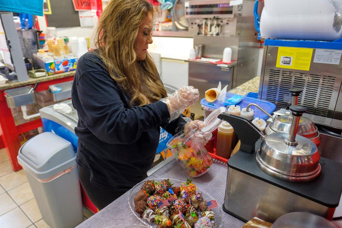 Debbie Serra, owner of Mr. G’s Ice Cream & Grill in North Myrtle Beach, demonstrates how she makes her dipped strawberries. She has such flavors as cookie butter, strawberry shortcake, chocolate and Fruity Pebbles cereal. The dipped strawberries are among her dessert creations at the shop. June 27, 2024.