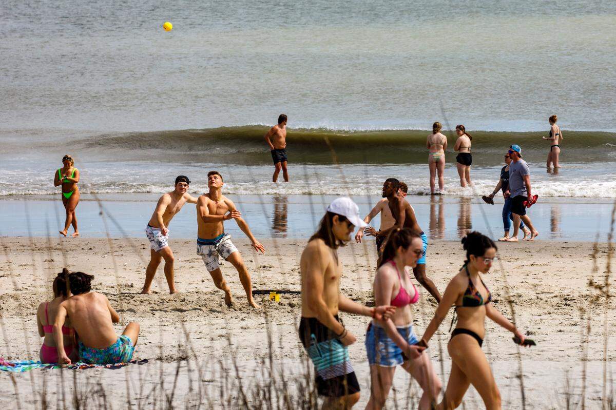 Students, most pictured from Rider University in New Jersey, play games and hang out on the beach in the downtown section of Myrtle Beach, S.C. Thousands of students visit the Grand Strand from late February to early April from Spring Break every year. March 17, 2022.