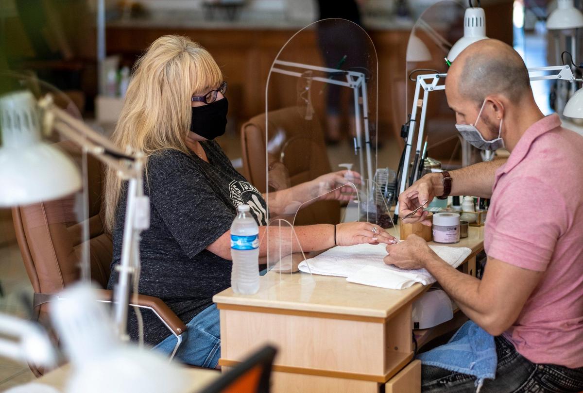 Tony Tran gives Ellie Fischer of Pawley’s Island a manicure through a plexiglass shield on Monday morning. The Four Seasons Nails & Spa in Murrells Inlet resumed operations on Monday following new SCDEC guidelines during the coronavirus pandemic. May 18, 2020