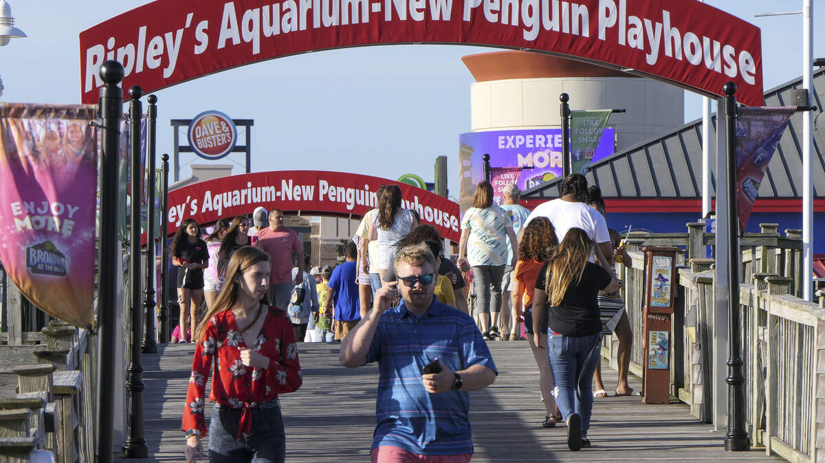 Shoppers and diners walk Broadway at the Beach.