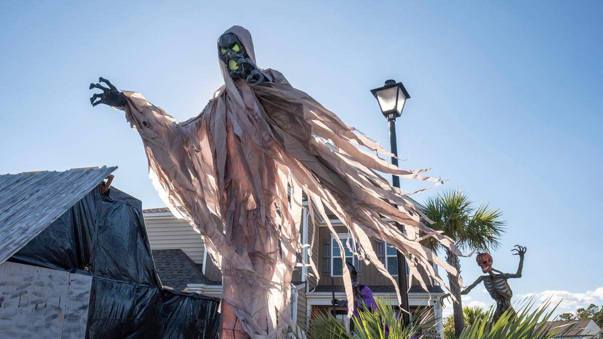 This October 2022 file photo shows a giant ghost-like figure looming over a neighborhood Halloween haunted house display in Horry County, South Carolina.