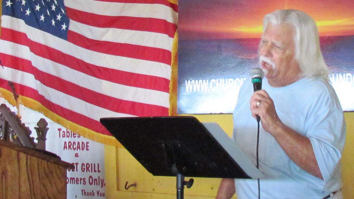 Donny Trexler, who sings and works the sound board
at the OD Church of the Lost and Found services in North Myrtle
Beach, encourages the congregation to sing along.