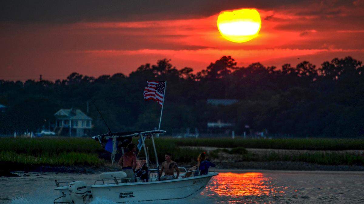 Boaters  with an American flag off Garden City Beach.