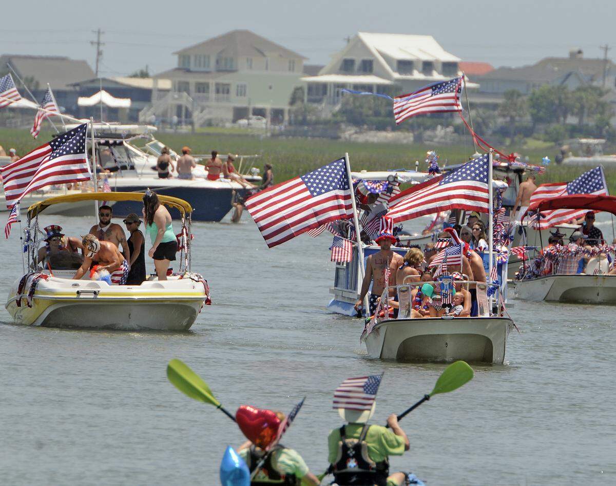 Thousands packed the waterfront in Murrells Inlet to watch the 31st Annual Murrells Inlet 'Fourth of July Boat Parade'. This year's parade theme was "Saluting Our Founding Fathers". Many exchanged water gun fire with people on the docks or on other boats on the hot sunny afternoon.