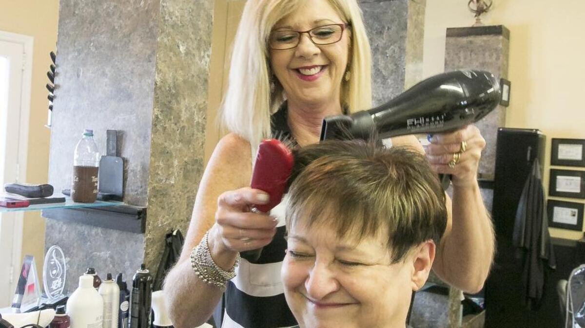 
Cosmetologist and salon owner Tami Floyd-Fogleman has received the National Sunrise Award for American Cancer Society through her volunteer work helping women with cancer through the Look Good Feel Better (LGFB) program. Floyd-Fogleman colors and styles Joanie Buckley’s hair at her studio. Buckley is a cancer survivor and regular client of Tami & Company Salon.
