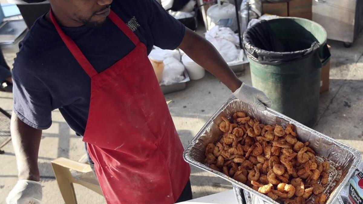 
Shrimp is seasoned for the Bimini’s Oyster Bar and Seafood Cafe booth at last year’s Taste of the Town

