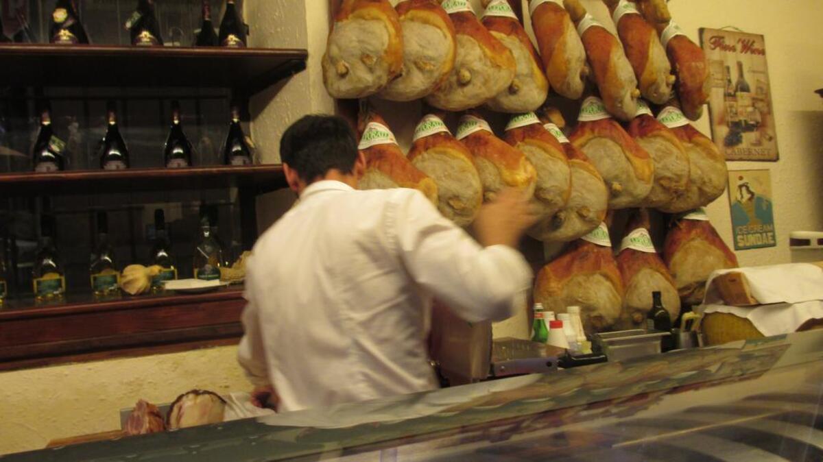 Local restaurant in Parma Italy slices hams with crown denoting them as real, original prosciutto di parma.