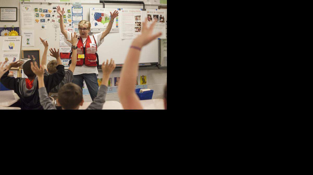 
Gini Calchera of the American Red Cross teaches children about hurricane preparedness. Pillowcases, used to hold emergency supplies, become art projects to get the students involved.
