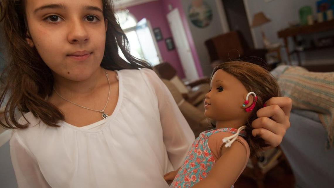 
Nine year old Annika Villafranca of Murrells Inlet pulls back her doll’s hair to reveal her hearing aids, which are pink, just like Annika’s.
