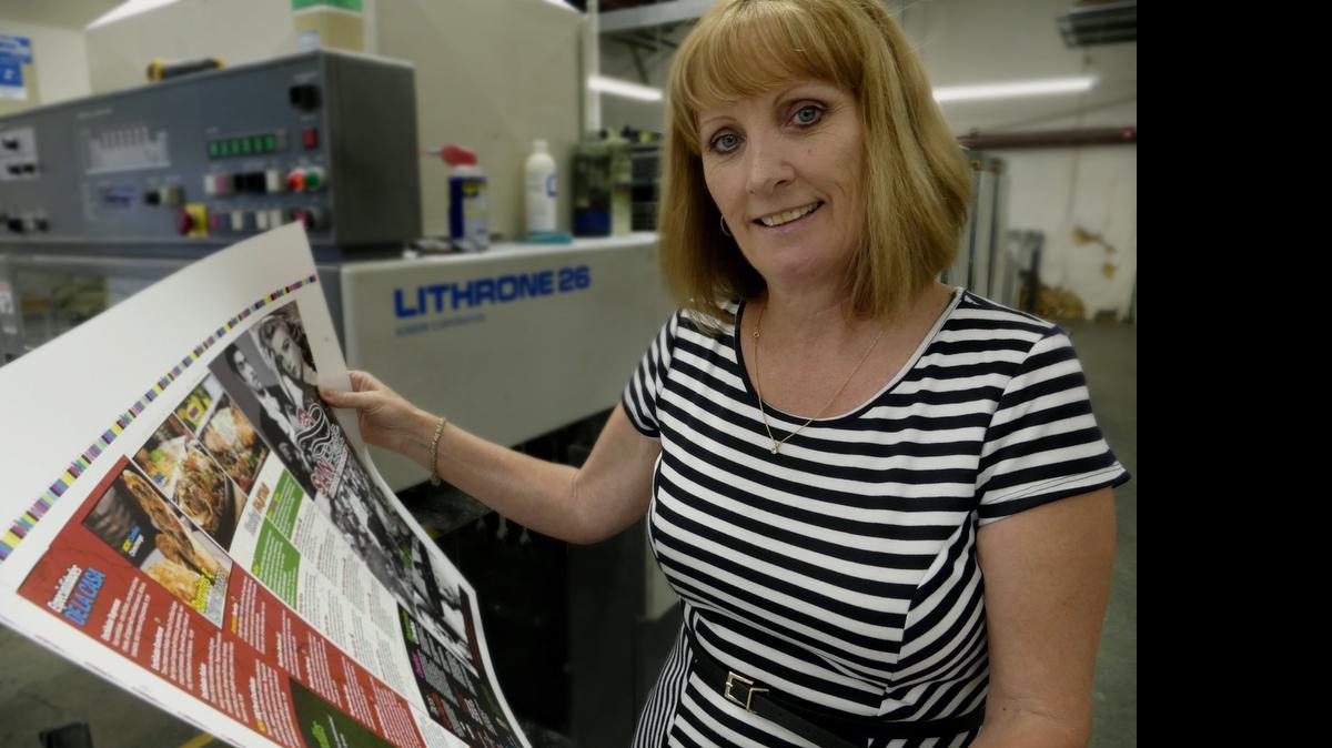 
Trish Sports, GM of Sheriar Press in Myrtle Beach who has just been elected chairwoman of the Printing Industry of the Carolinas, looks over a proof from the offset six color press.
