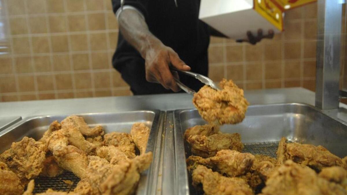 07.25.2011 An employee at Bonjangles’ 3rd Street location loads a box of fried chicken for a drive-through customer.