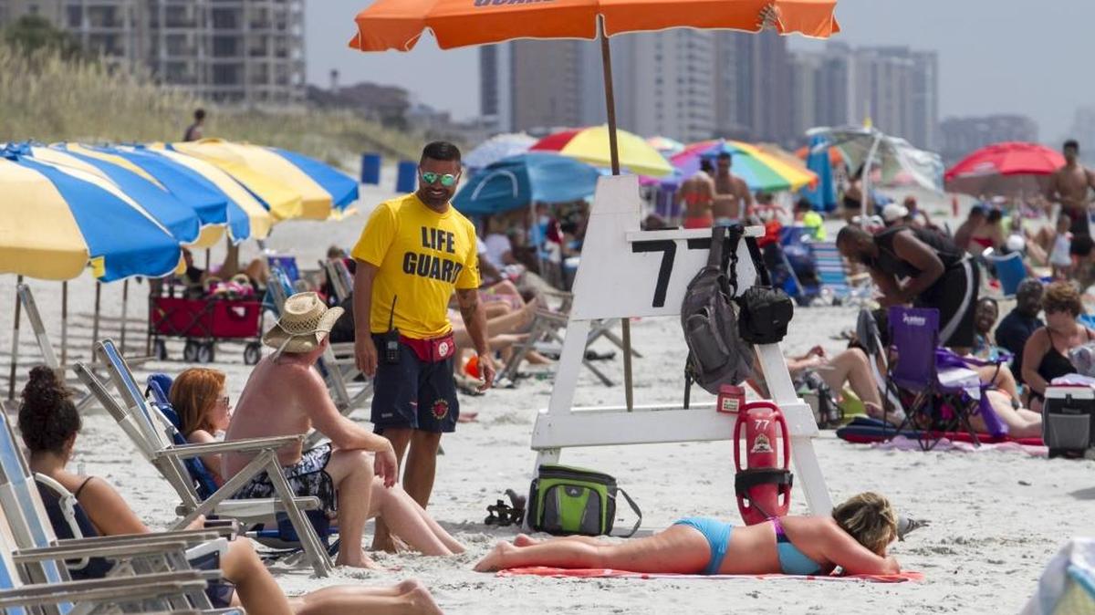 Lifeguard David Starr talks with visitors as he patrols his area at 77th Ave. North in Myrtle Beach during a 4th of July weekend.