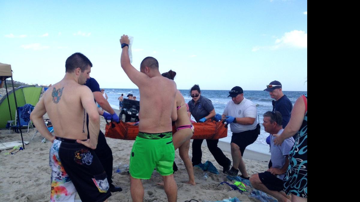 
Emergency responders assist a teenage girl at the scene of a shark attack in Oak Island, N.C., Sunday, June 14, 2015. 
