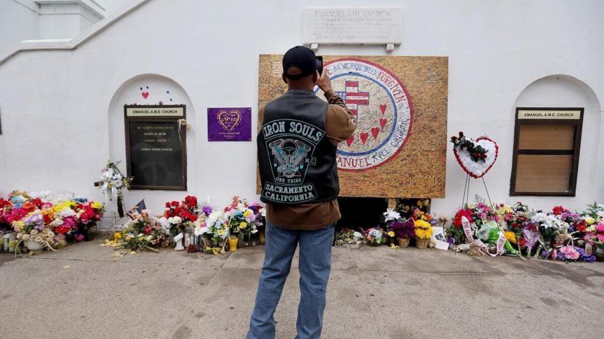 
In this photo taken Aug. 4, 2015, Raphael Frazier, who traveled with his motorcycle club Iron Souls, from Sacramento, Calif., takes photos outside Emanuel AME Church on in Charleston, S.C., as the group visited the site of the June 17 shooting of nine parishioners.

