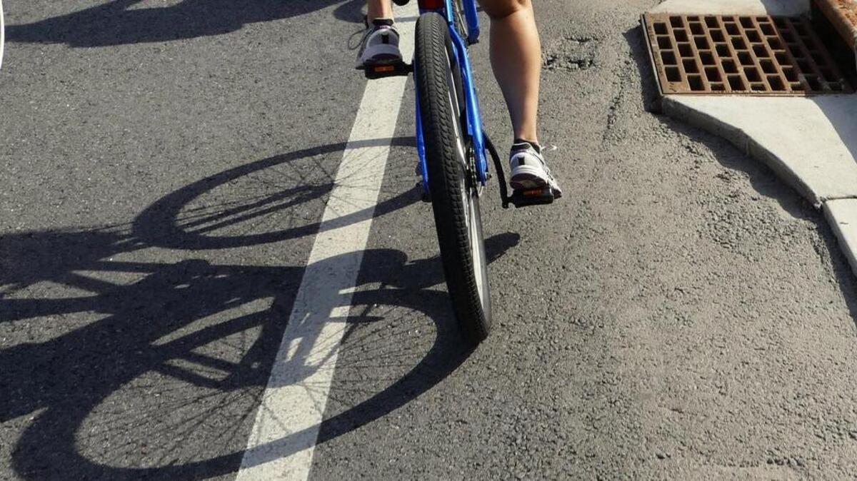 Transportation designer Angela Callan, with the VHB consulting firm, rides past one of the noted bike lane problems on Ocean Boulevard. The storm drains intrude into the bike lane forcing riders closer to traffic. The concrete lip was also discussed by city staffers who pointed out that the paving was not complete on this section of the street.