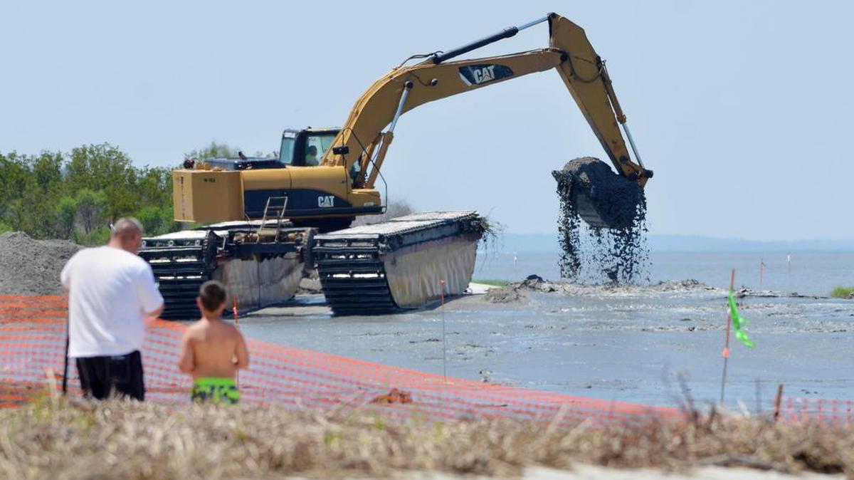 Beachgoers watch from behind a safety fence in Fish Haul Creek Park in June as a Hilton Head beach nourishment project gets underway at Mitchelville Beach Park.