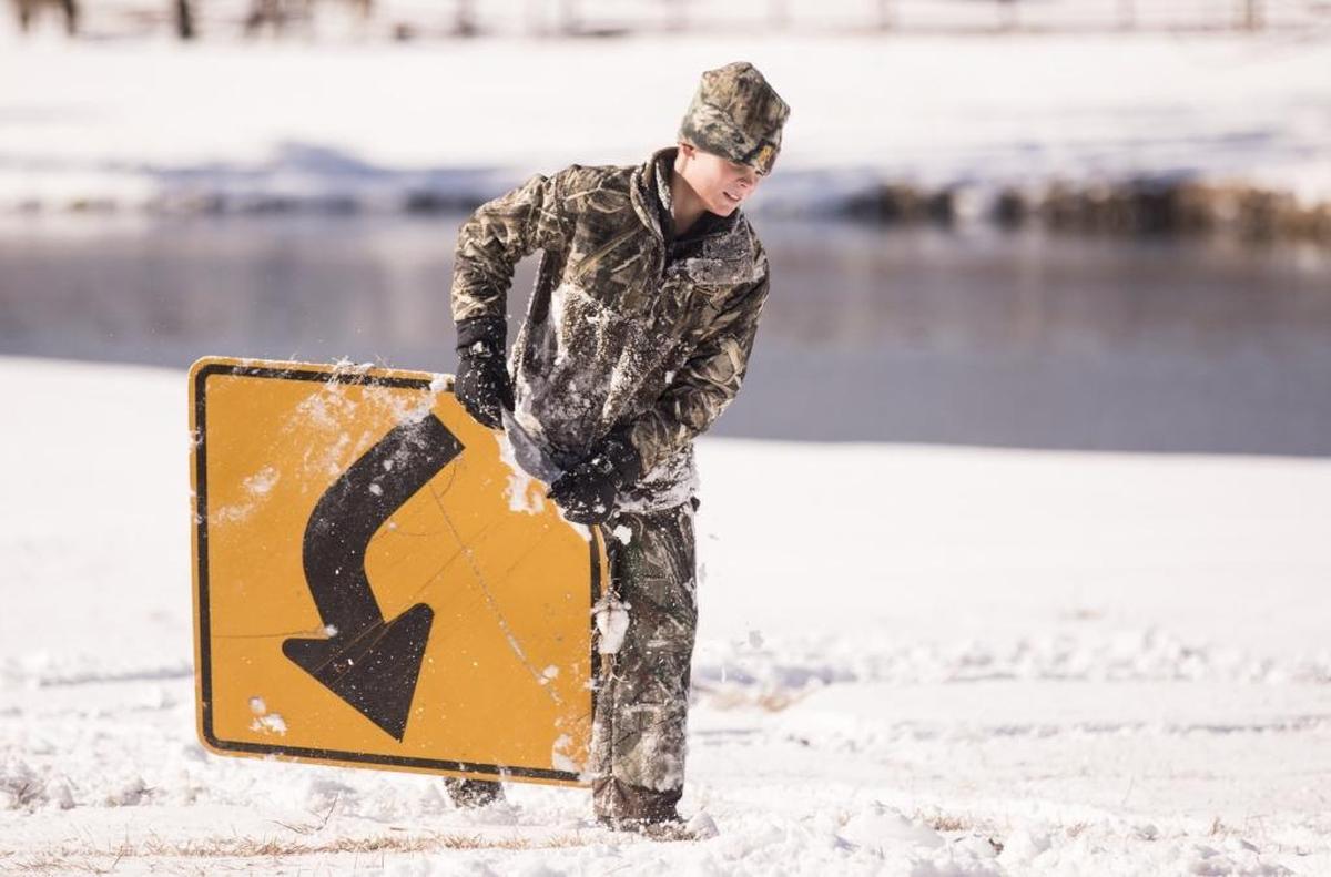 Jedd Alan Hess, age 11, carries a old road sign that was being used as a makeshift sled pulled behind a 4-wheeler at the Harrelson family farm outside of Aynor on Thursday. While much of the Grand Strand missed the heaviest snowfall from Winter Storm Grayson, residents of Aynor woke up to over three inches of snow on Thursday. Jan. 4, 2018.