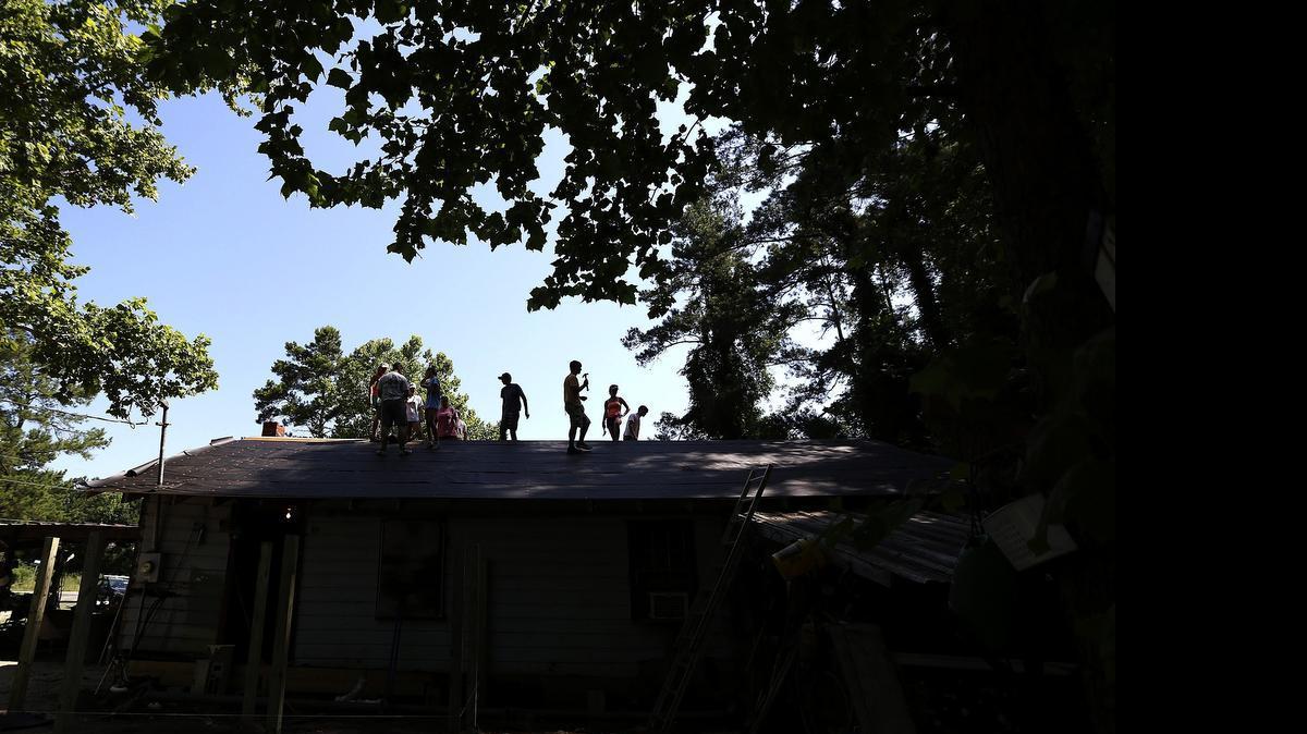 
Volunteers in the Salkehatchie Summer Service camps bake in the sun as they repair the roof of Jack Parker’s home outside of Conway on Wednesday, June 17, 2015. About 120 volunteers are working on seven houses this week as part of the summer youth mission program with United Methodist Churches in South Carolina. Challenges begin with the physical labor but this week’s heat has added to the load.
