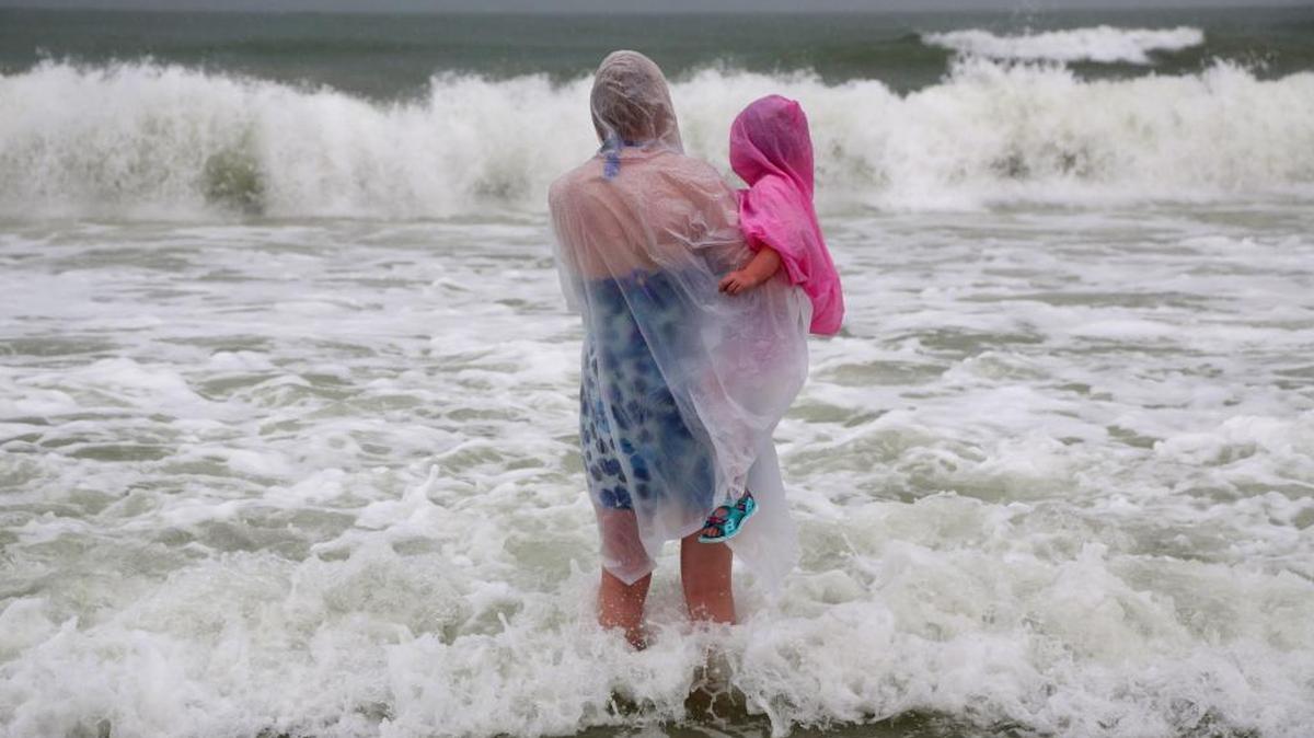 Lisa Bolton holds her three-year-old daughter Lois Bolton, both of Manchester, England, during a visit on Wednesday, Aug. 31, 2016, to Clearwater Beach, Fla. The National Hurricane Center in Miami says Tropical Storm Hermine is gaining strength as it rumbles toward Florida's Gulf Coast.
