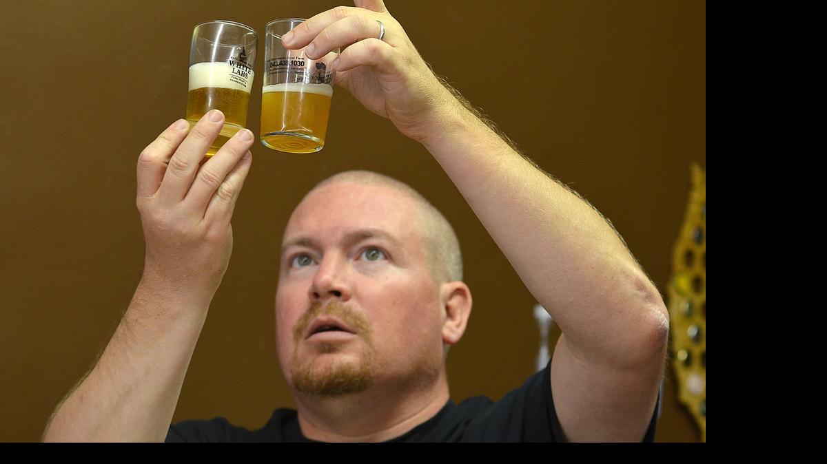 
Thomas Lucas, owner of Homebrewer's Pantry in Conway, looks at the clarity of submitted samples of home-brewed beer during a Friday night beer tasting at the store. 
