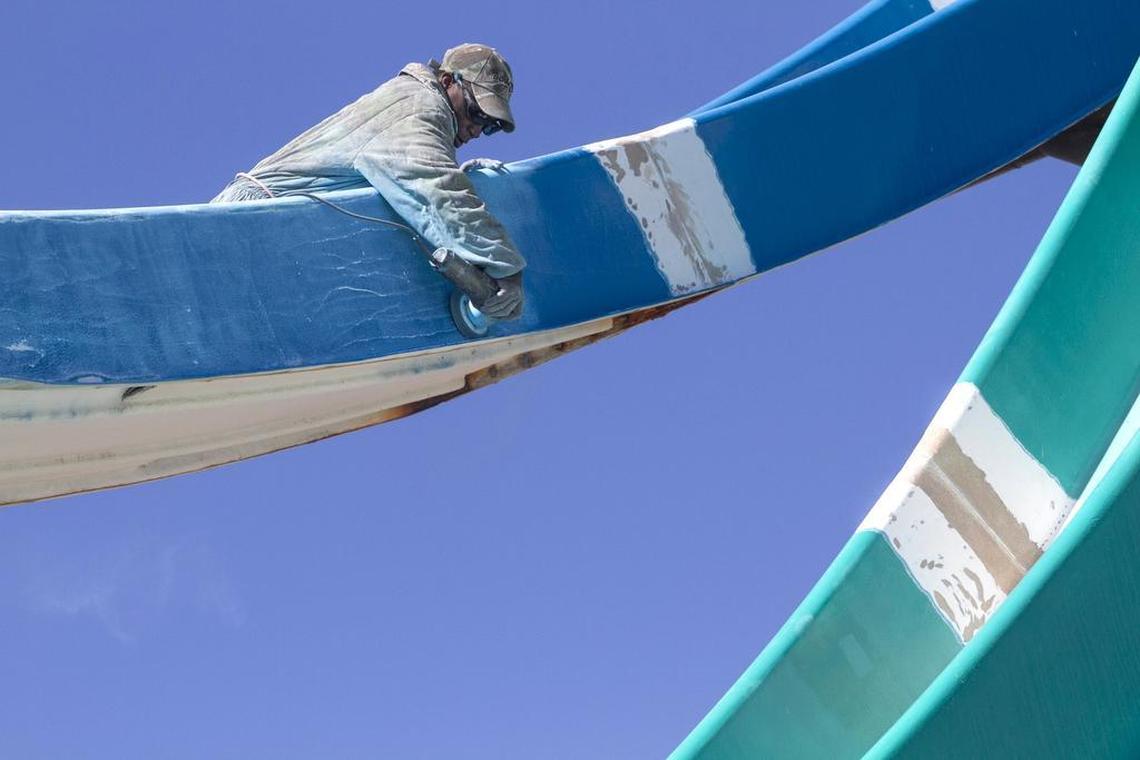 James Harps sands a water slide at Wild Water & Wheels in Surfside Beach in preparation for the season.
