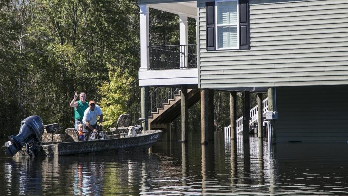 William Johnson pulls up to his home in a boat on Riverfront Road in the Bucksville community after a flood last fall along the Waccamaw River.