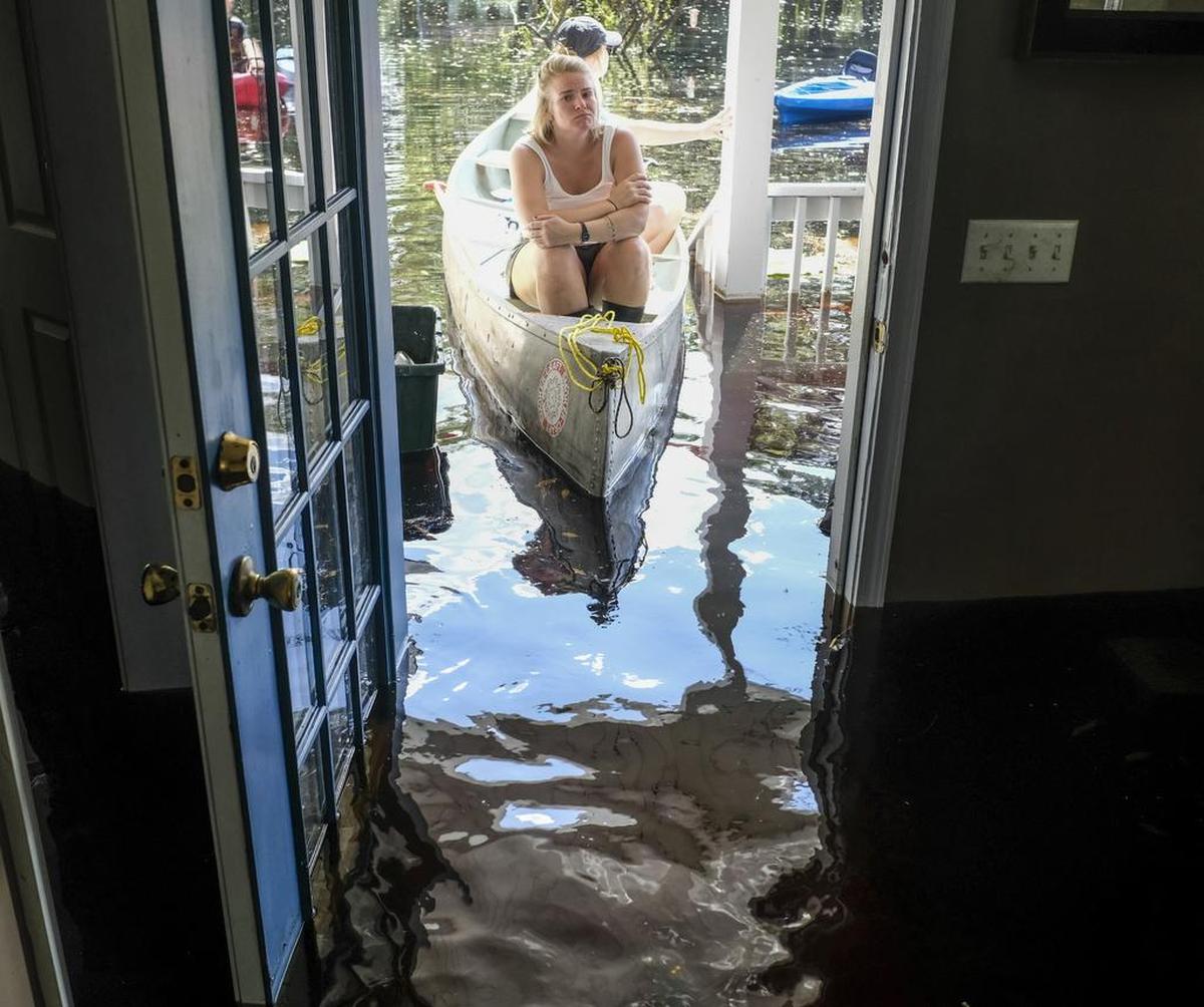Maura Walbourne sits in the front of a canoe looking in at her flooded Long Avenue home as David Covington wades through the wreckage. The Sherwood Drive area of Conway, S.C., began to look like a lake on Sunday as homes were submerged deeper than ever in flood waters that have already set historic records. Sept. 22, 2018.