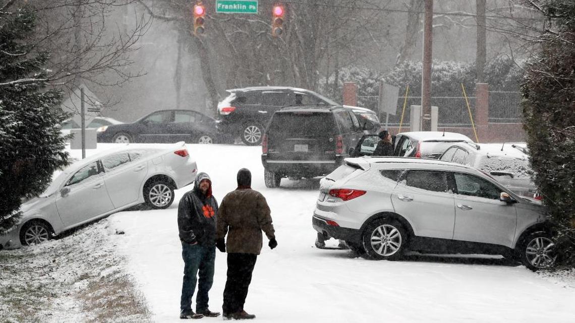 Motorists talk outside their cars after being involved in several accidents due to icy roads Friday in Nashville, Tenn. Winter weather closed schools and made driving conditions hazardous.