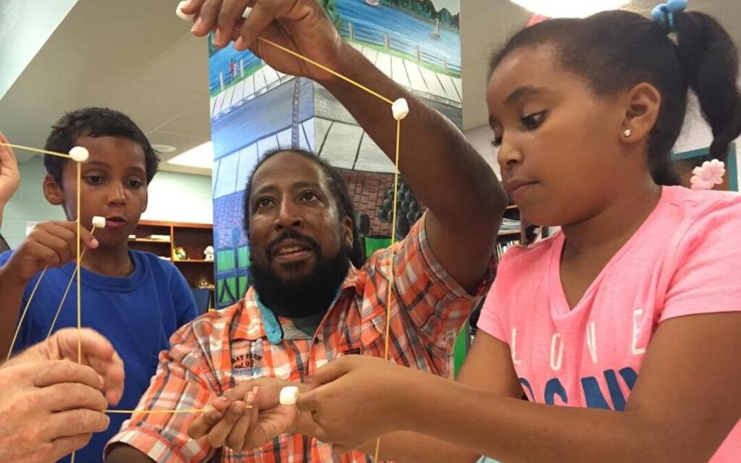 
Cody Slate, left, helps Lee Edwards and his daughter Jami build a tower out of spaghetti and marshmallows at the “Team Dad” event. Families tried to piece together the tallest tower using just a few supplies on Tuesday.
