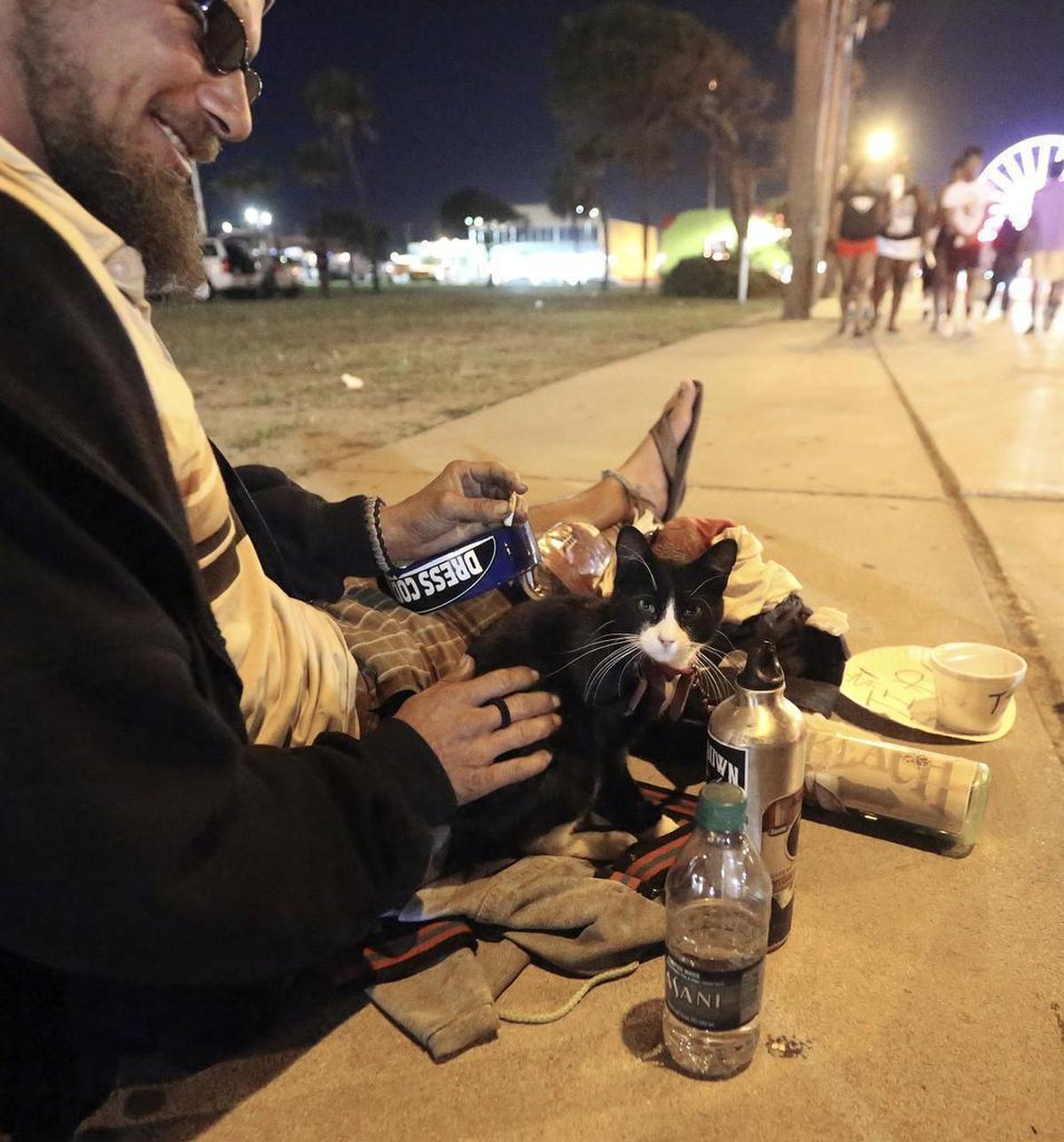 John Shows plays his ukulele with his kitten Showtime as people pass by on Ocean Boulevard on Saturday, May 23, 2015, during Atlantic Beach Bikefest in Myrtle Beach. Shows strums for money he plans to use to head north. Showtime has been with Shows for 10 months after they found each other in Panama City Beach, Fla.