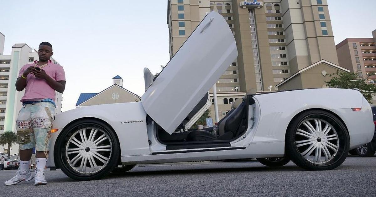 Eli Oliver of Rock Hill stands with his 2013 Camaro with Lamborghani doors and 24-inch wheels on Ocean Boulevard in Myrtle Beach for the annual Memorial Day Bikefest on Saturday.