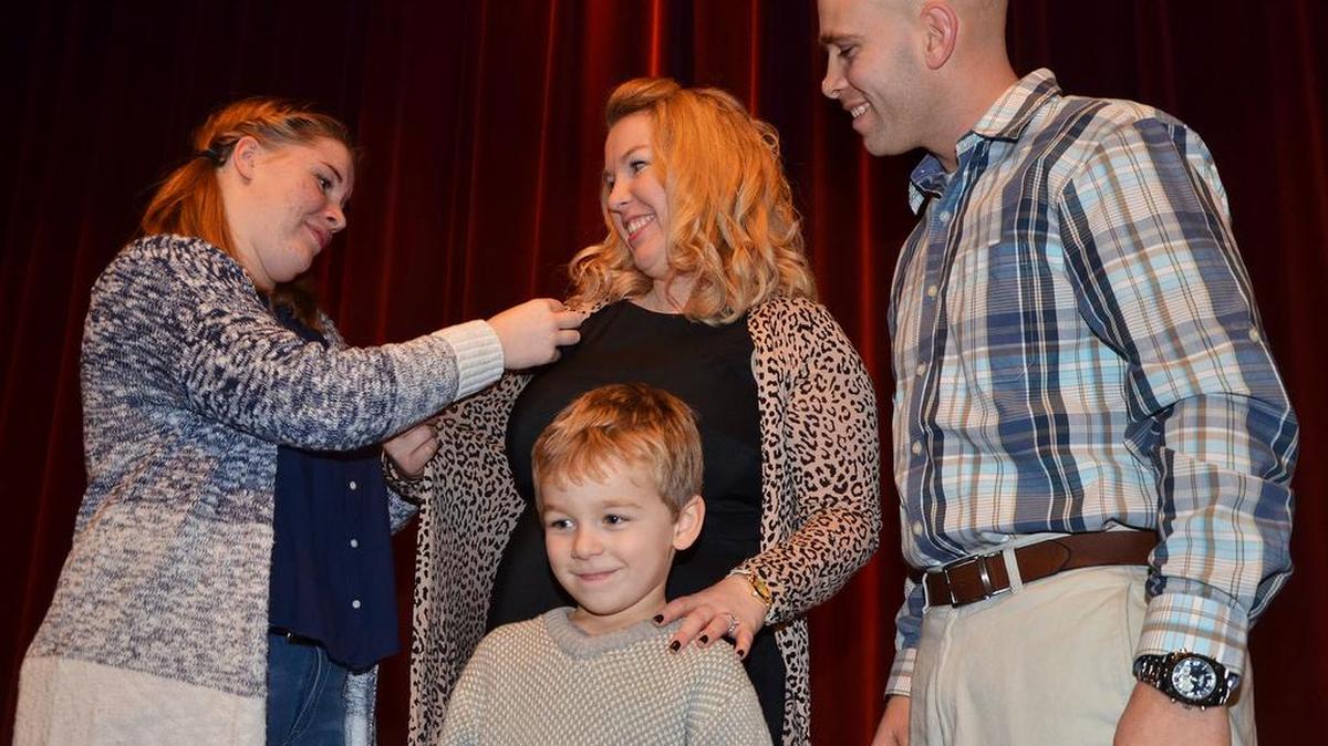 Des Moines Area Community College Boone Campus student Stacy Harrison (center) receives a nursing pin from her daughter, 14-year old McKenzy Harrison, her son, five-year old Chase Harrison and her husband, Chris Harrison, in a ceremony recently held on the DMACC Boone Campus. Stacy Harrison graduated from DMACC’s Practical Nursing program.