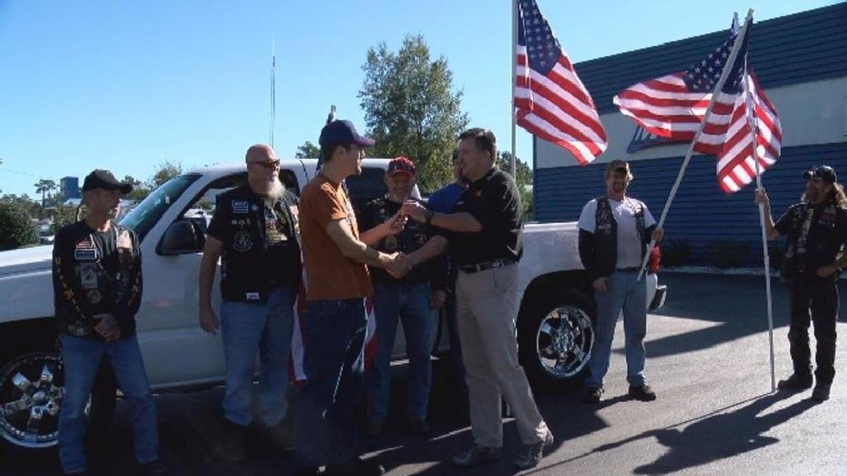 Joe Johnson, owner of Maaco Myrtle Beach, hands over the keys to the refurbished truck