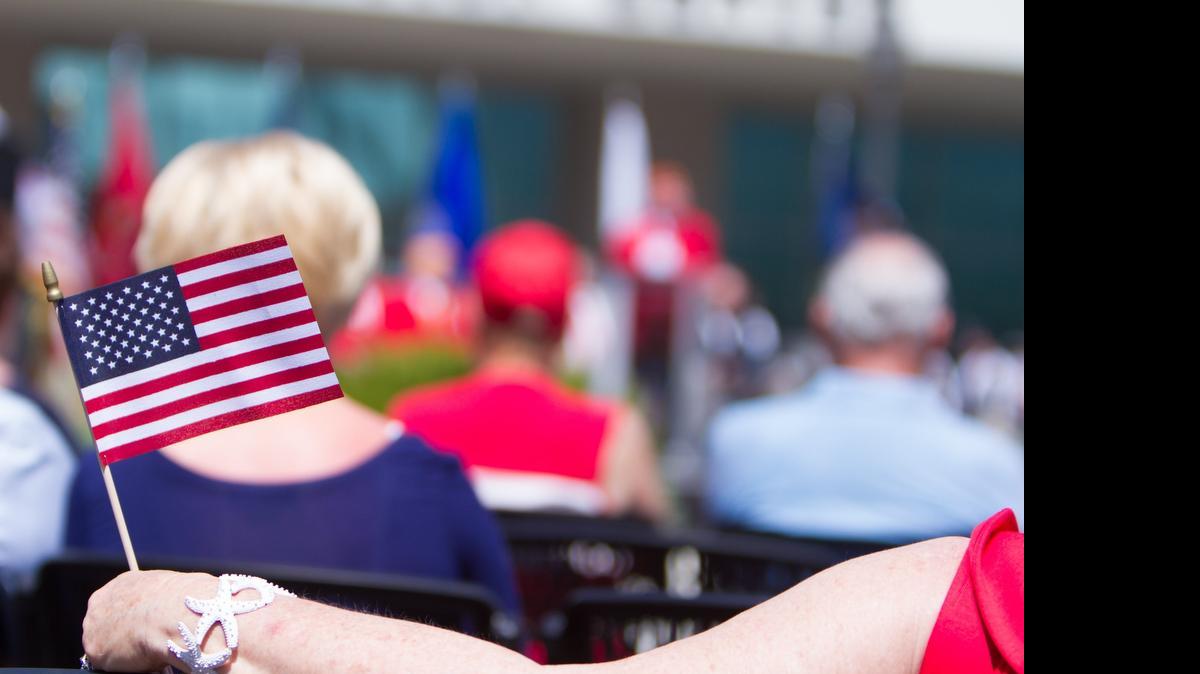 
An audience member holds a miniature American flag at the 2015 Memorial Day ceremony at the Myrtle Beach Convention Center May 25.
