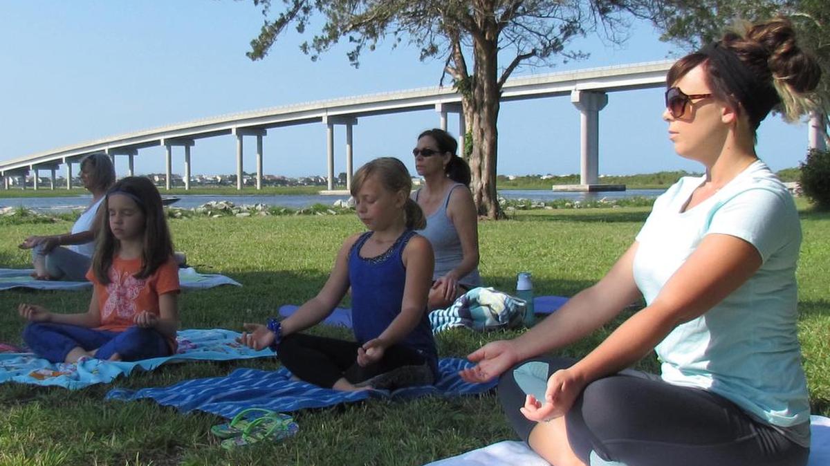 Yoga in the Park at Sunset Beach, N.C. is a popular class on Saturday mornings. Leslie Hansbarger (left) of Sunset Beach, Mia Leonard of Calabash, N.C., Abbie Hetnick next to her mother Jackie Hetnick, both of Sunset Beach and Tina Ward (back row) of Ocean Isle Beach, N.C. sit in a lotus-like pose.
