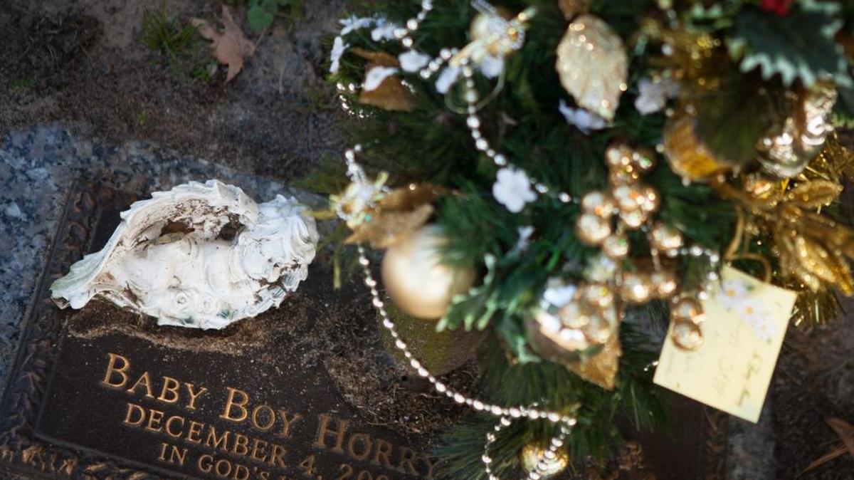 Reverend Wayne Brown and Lead County Coroner Robert Edge remember "Baby Boy Horry" Hillcrest Cemetery in Conway. The child, who was found dead in a shopping bag in a wooded area nearly five years ago, was just days old when he was left to the elements.
