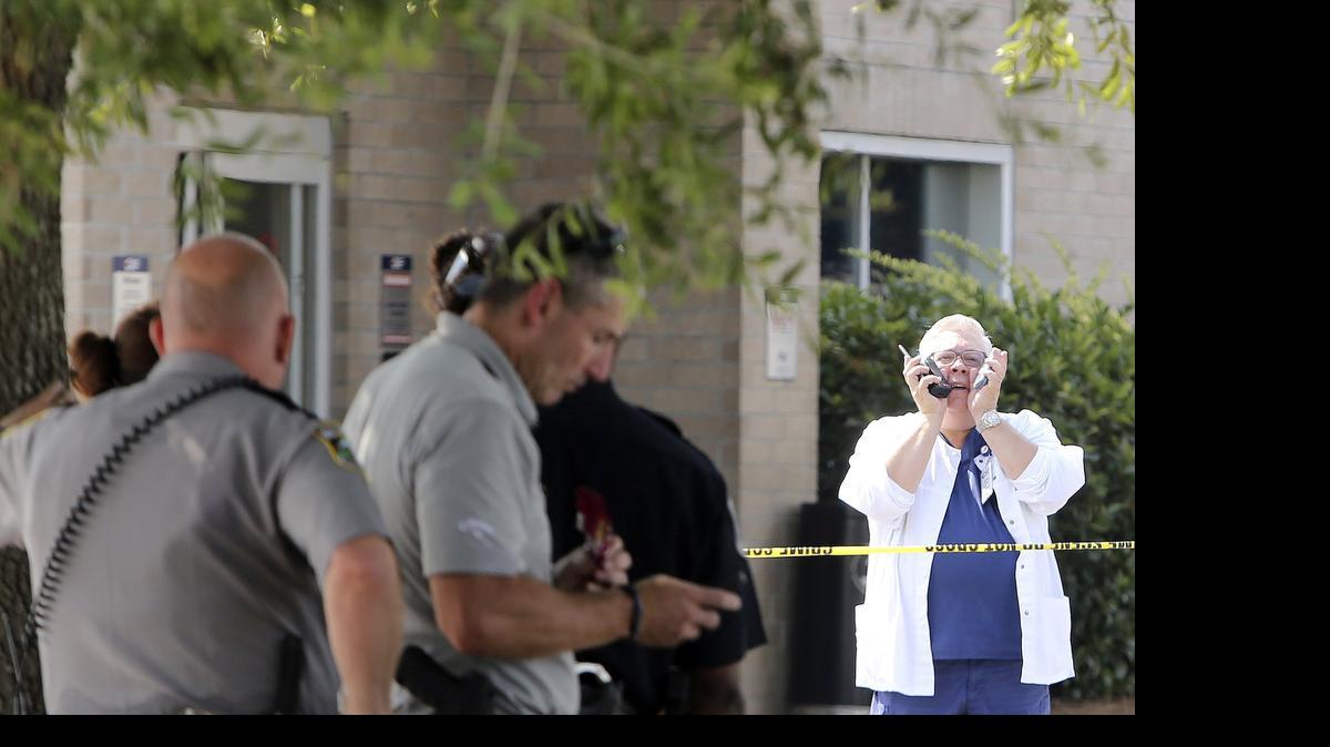 
A Conway Medical Center staff yells out from inside the crime scene tape as hazardous materials response units work the scene at the ambulance bay and emergency room entrance on Thursday.
