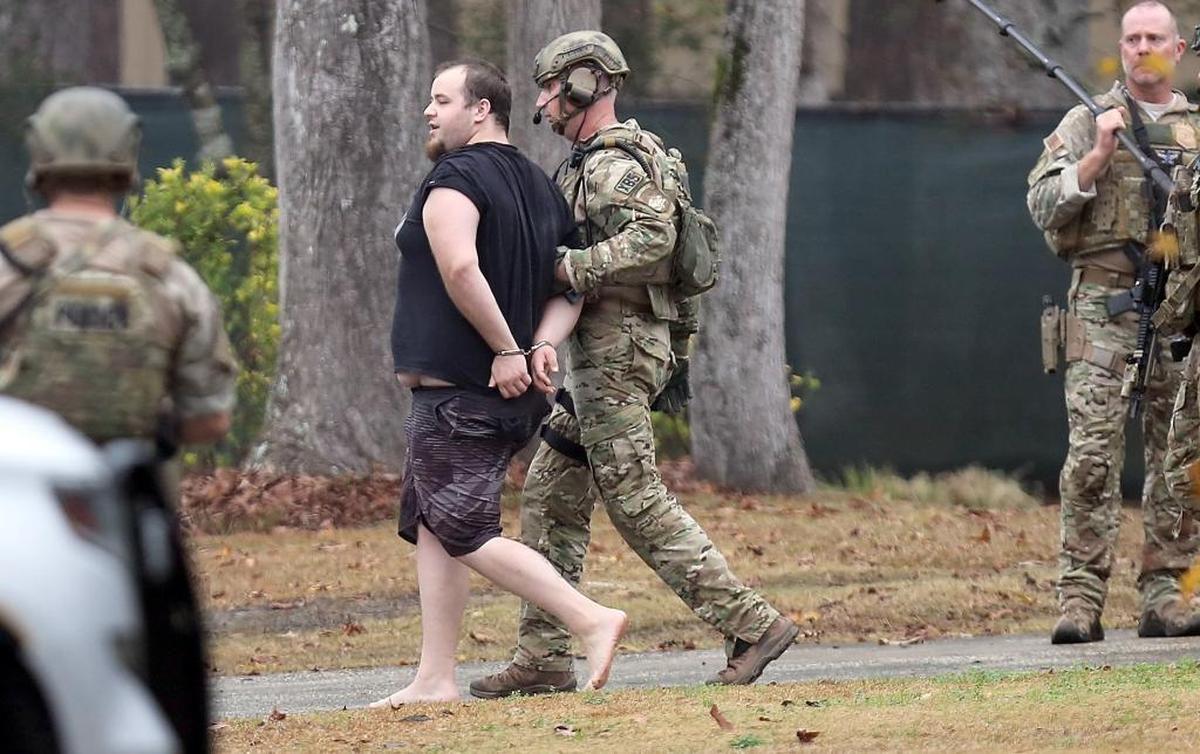 A man in handcuffs is taken away from a home off Willow Ridge Road in the Socastee community as a standoff ends on Sunday, Dec. 24, 2017. Horry County Police SWAT and Negotiations team with other personnel responded to a call of a barricaded subject hours earlier.