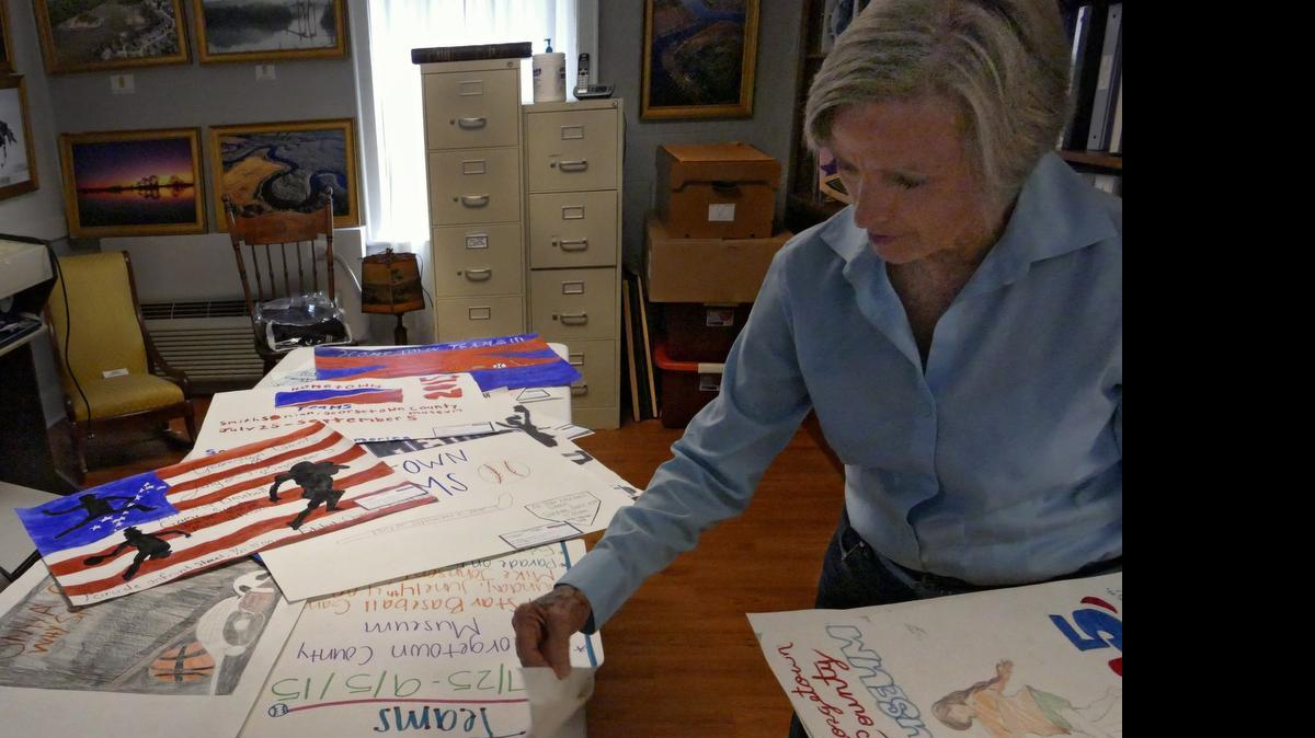 
Georgetown County Museum volunteer, Jan McGinty looks through some of the posters produced by the Georgetown County high schools that will be placed in store windows to celebrate the Smithsonian Institution's Exhibition Hometown Teams "How Sports Shape America.” The exhibit will open July 25 and run through Sept. 5.
