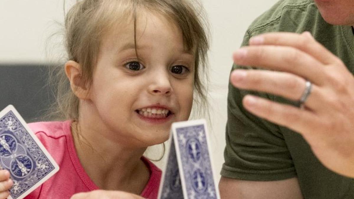 Chloe, age 4, and her father Zack Wilsey, build a house of cards during the "Team Dad" program at Riverside Elementary School. About 100 fathers joined their children for a night of games and team building exercises as part of the "Team Dad" program. The youth and their fathers took part in art projects, played strategy games, learned about communication skills, and had dinner together on Tuesday, Oct. 25, 2016.