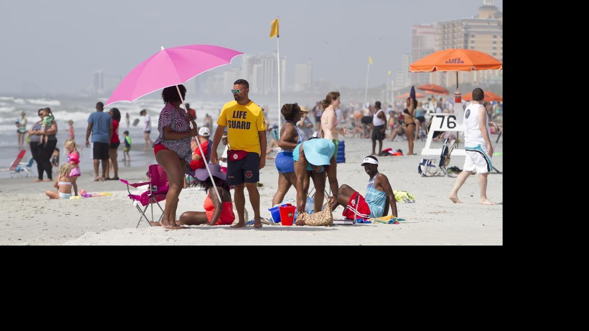 
Lifeguard Denny Starr asks a tourist to move her umbrella behind the guard stands to provide him a clear view of swimmers at 76th Ave. North in Myrtle Beach. Lifeguards from Gene's Beach Service patrol the North end of Myrtle Beach expecting large crowds of sunbathers for the July 4th weekend.
