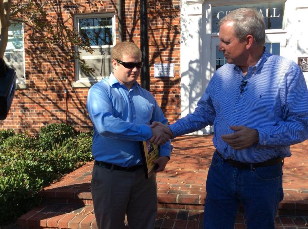 Volunteer firefighter Bubba Hinson, left, shakes hands with Myrtle Beach mayoral candidate Ed Carey following a Friday press conference Friday.