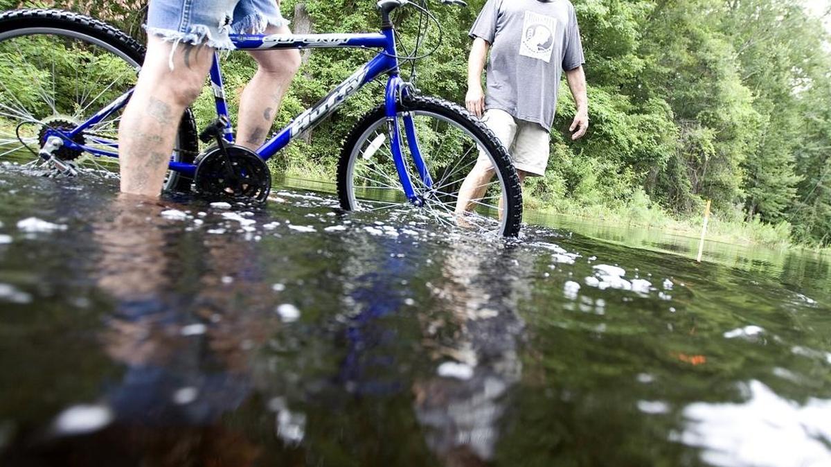 
Eddie Letellier (right) listens as Frank Shuman talks about riding his bicycle through the flooded streets at in the Lee's Landing community.
