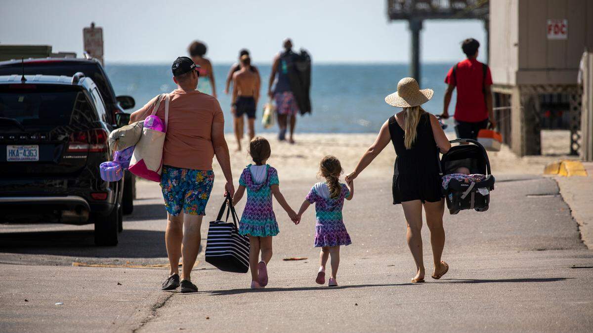 A family makes their way to the beach at Springmaid Pier on Tuesday. July 19, 2022.