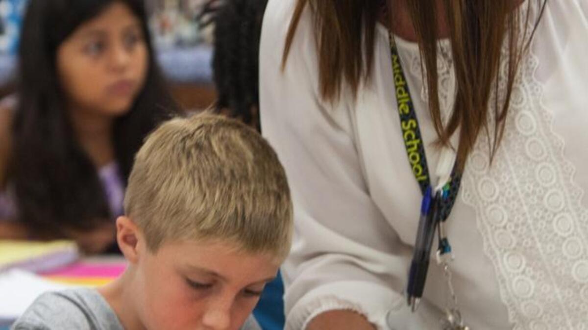 
Sixth grade teacher Batrice Haigh helps Brandon Pjifer label his notebook dividers. Students at Whittemore Park Middle School in Conway spend their Friday mornings with teachers they may not normally have during what the school calls "I Can R.O.A.R.(Respect, Organization, Achievement and Responsibility)." The 40-minute sessions foster one-on-one interaction, organization and accountability by focusing on students' needs in small groups. The educators leading the groups will track how each student is doing throughout the year and from class to class, through a universal organization system.
