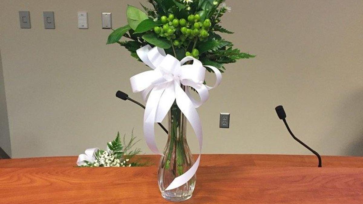 Kay Loftus’ seat is adorned with a single white rose during the first Horry County Board of Education meeting after her death. The board will appoint her replacement Monday.