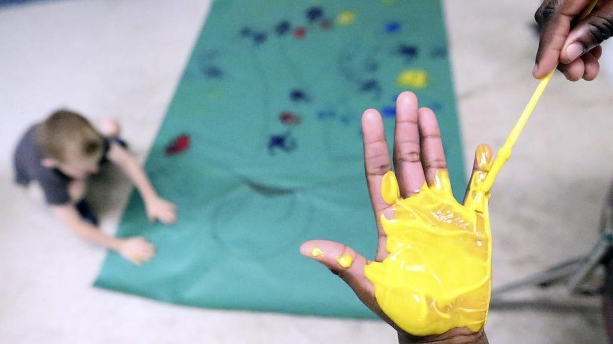 Ambria McKnight paints her hand to place on a life-size drawing at the Boys & Girls Club of the Grand Strand inside the Family Learning Center on Oak Street in Myrtle Beach on Sept. 30. Horry County Schools is going to tear down the learning center for a new middle school. The center houses the Boys & Girls Club and other tenants that include programs for adult education and GED classes.