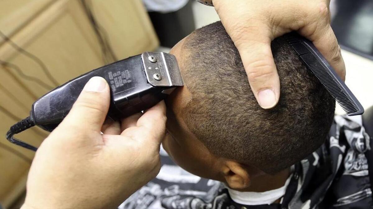 
Jordan Gause gets a straight line by John Young at Cuttin' Up Barber Shop for the free back-to-school haircuts for boys on Monday, Aug. 17, 2015. 
