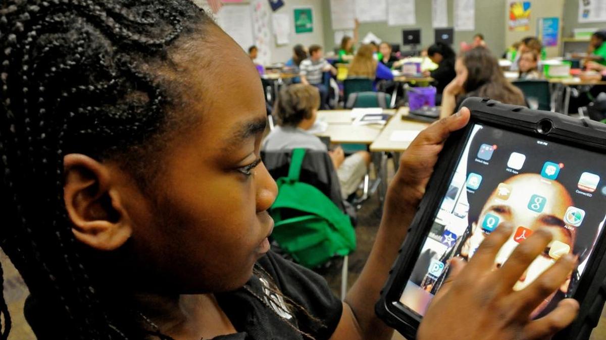Forestbrook Middle School sixth grader Xavier Gore shows how each student's iPad has their photo as the homepage background.